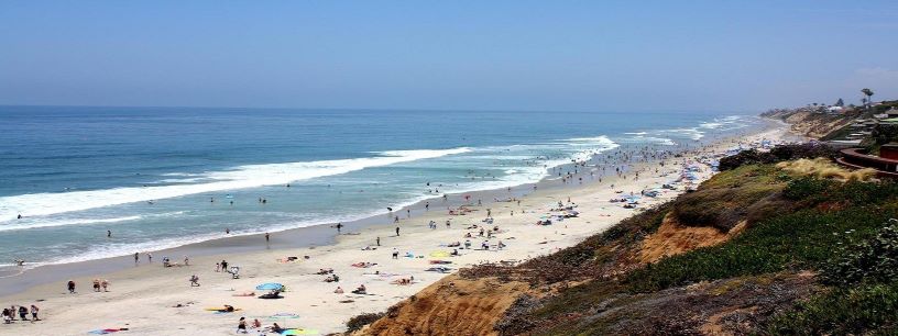 Photograph of D Street Lookout over Moonlight Beach, Encinitas, CA looking north. Beach bathers, cliffside, and ocean shown.